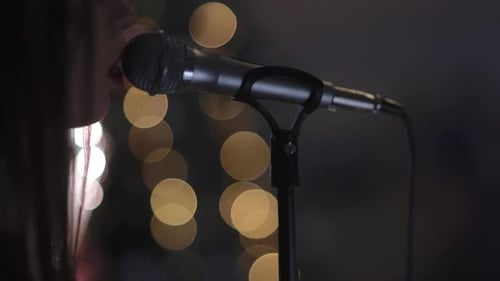 Singer Performing on Stage in Front of Dark Background