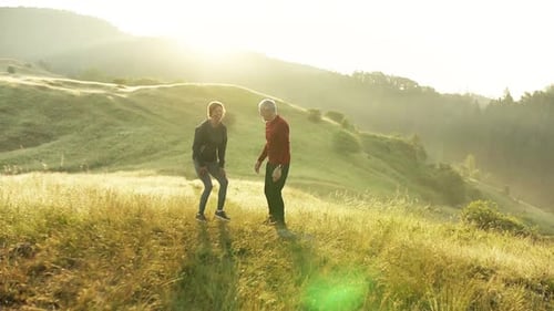Senior Couple Runners Stretching On Meadow Outdoors At Sunrise In Nature.