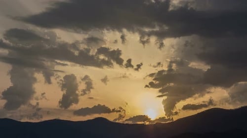 Sunset over the mountains. Timelapse of day to dusk in a mountain landscape. Silhouette of the hill