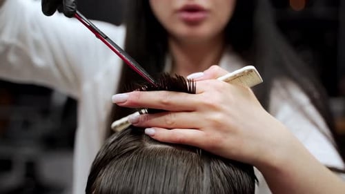 Hair Stylist Cuts Client's Dark Hair in Salon