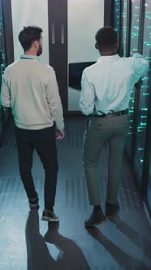 Two Skilled Professionals Walking Through a Modern Technologyfocused Environment Together
