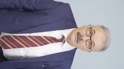 Professional Man in Suit Gesturing with Arms Crossed