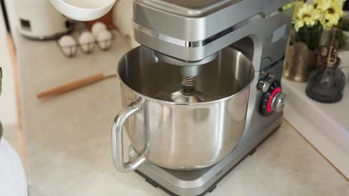 Flour Being Poured Into Electric Mixer During Baking Process in Home Kitchen