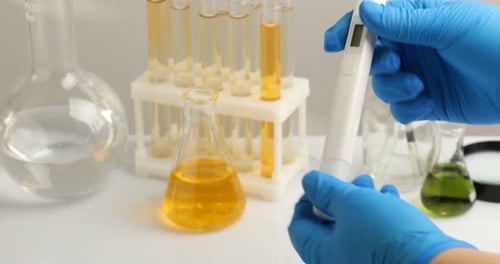 Scientifique testant l'eau avec un compteur de qualité à une table blanche, gros plan