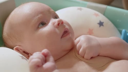 Infant Lying Back Relaxing in Baby Bath Tub