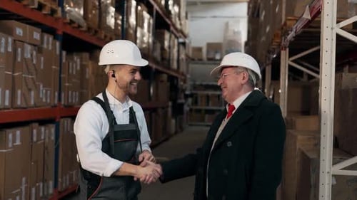 Warehouse Worker Showing Tablet to Senior Employee