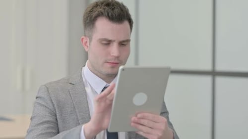 Young Adult Using Tablet in Modern Office