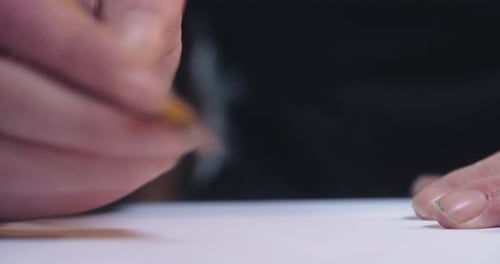 Close-up of a hand working with a pencil in a sketchbook