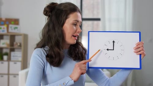 Distant Education, Primary School and Teaching Concept - Female Teacher with Clock