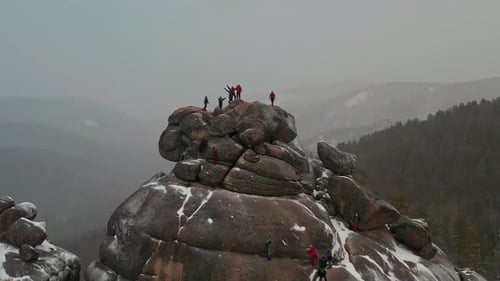 Hikers Celebrate Reaching Mountain Peak in Wintery Conditions