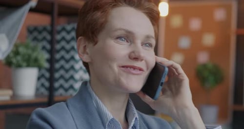 Cheerful Businesswoman Making Mobile Phone Call Discussing Work Smiling Talking Indoors in Office