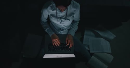 Slow motion top view of a young beautiful business woman is working with a computer in the evening