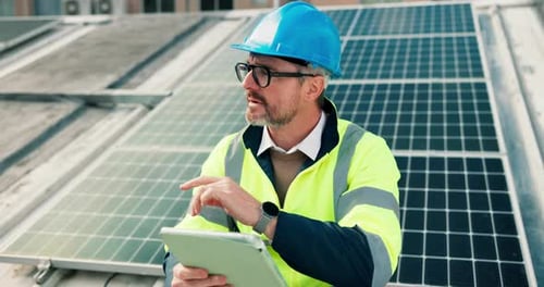 Engineer Inspects Solar Panels with Tablet Device