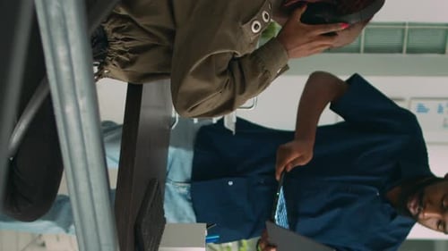 Vertical Video Team of Programmers Analyzing Coding Algorithms on Laptop and Computer