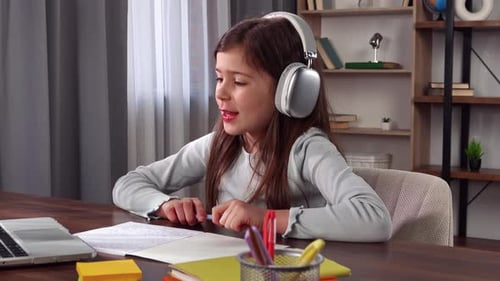 Young Child Girl Studying at Home Small Girl Sits at Desk and Attends School Class Online on Laptop