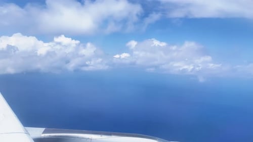 Blick aus dem Fenster auf die Ebene des blauen Himmels mit Wolkenhintergrund. Reisen Sie mit dem Flugzeug.