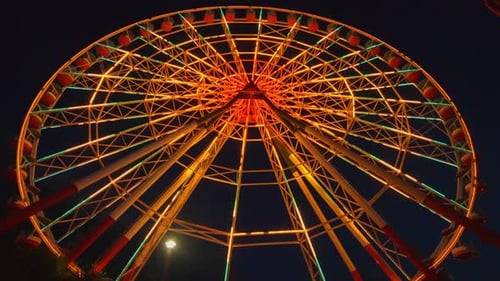 Brightly lit Ferris wheel in Georgia's Tsitsinatela amusement park.
