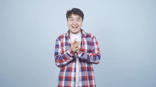Hombre aplaudiendo con entusiasmo a la cámara.