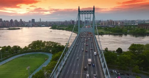 The Triborough bridge with moving cars against river and city panorama.