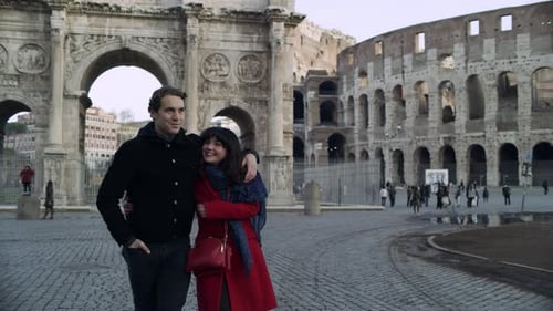 Happy, Cheerful Italian Couple Walk Together While Looking at the Buildings, Including