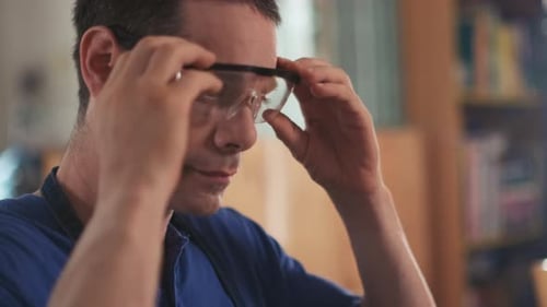 Man Puts On Clear Safety Glasses At Work