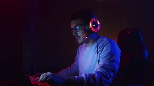 Young Male Gamer Plays Online Videogames Rejoices in Victory Claps Hands Side View