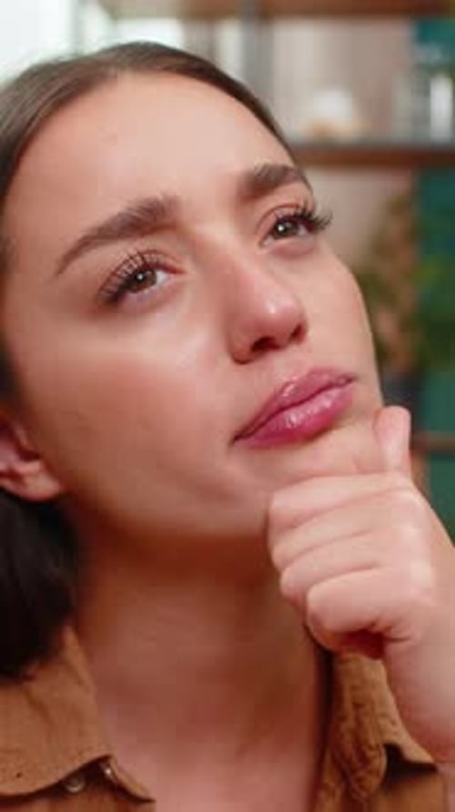 Young Woman Close Up Resting Chin on Hand Thinking Hard About Solution Looking for Creative Answer