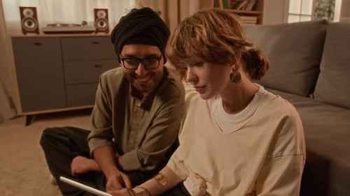 Young Man and Woman Looking at Tablet