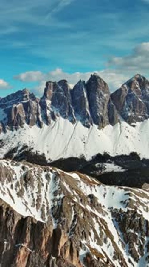 Rocky snow mountains at sunset aerial