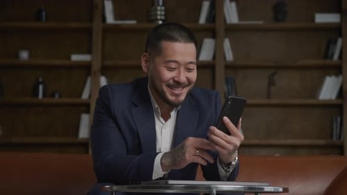 Man Speaking on Video Call in Office Using Smartphone