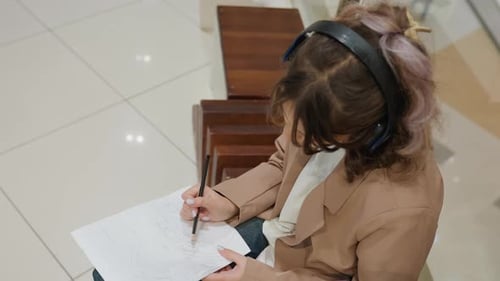 Woman Drawing on Paper with Pencil Indoors