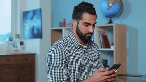 Man Using Smartphone Device in a Home Interior