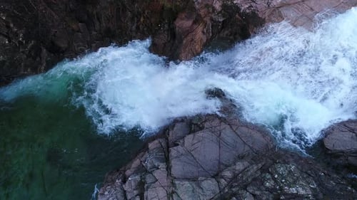 Waterfall Flows Through Rocky Gorge