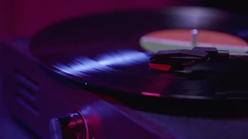 Close up of Vinyl Record player Spinning with cinematic red and blue lighting