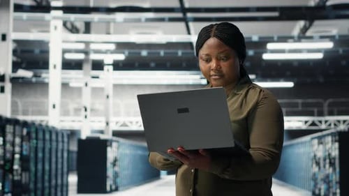 Programador em data center usando laptop para implantar nova arquitetura de servidor