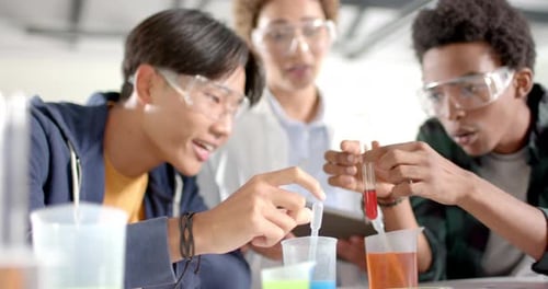 In high school, teenagers conducting science experiment with test tubes and beakers