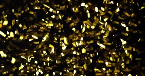 Golden Confetti Floating Down Against Dark Background