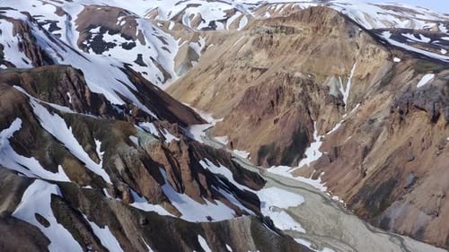 Drone view from top to bottom over Landmannalaugar's rhyolite mountains in Brandsgil valley, capturi