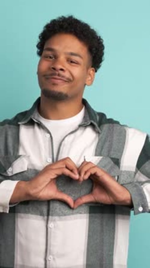 Young Adult Making Heart Shape with Hands