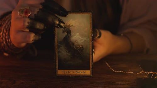 Woman displays tarot card with knight of swords image