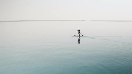 Man Paddle Boarding on Calm Blue Water
