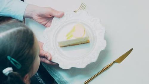 Slice of Lemon Cheesecake Presented to Child