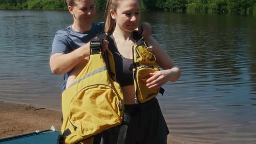 Adults Preparing for Watersports on Lake Shoreline