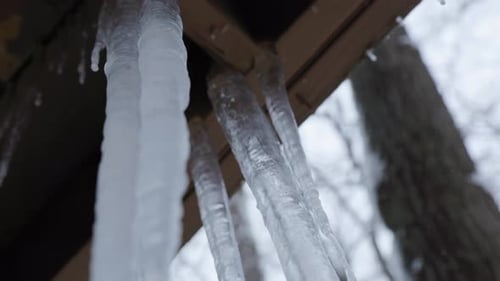 Handheld shot of icicles hanging off a balcony. Shot in 4k