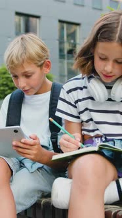 School Students Friends Outdoors Using Digital Tablet Computer Kids Sitting on Bench and Play on