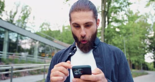 Close Up of Man Holds Smartphone Happy to Receive Notification Gestures Actively From Happiness