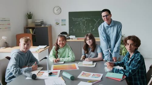 Portrait of Teacher Assisting Students Building Wind Turbine Models in Classroom