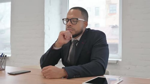 Pensive Mixed Race Businessman Sitting in Office