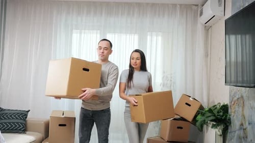 Couple Moving Boxes Into New Home