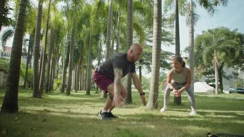 Homme faisant des burpees pendant l'entraînement avec une entraîneuse personnelle